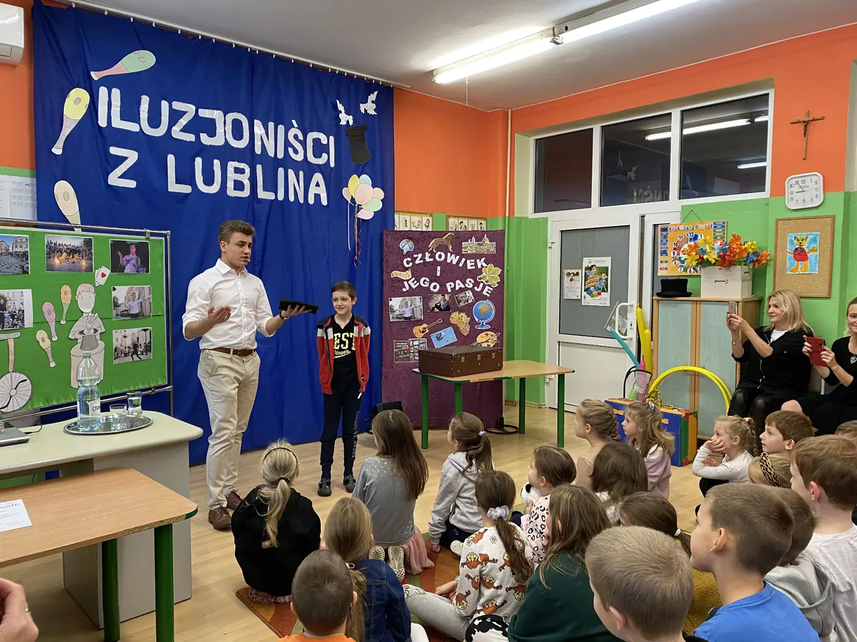 Iluzjonista z Lublina Bartosz Rybczyński występujący przed grupą dzieci