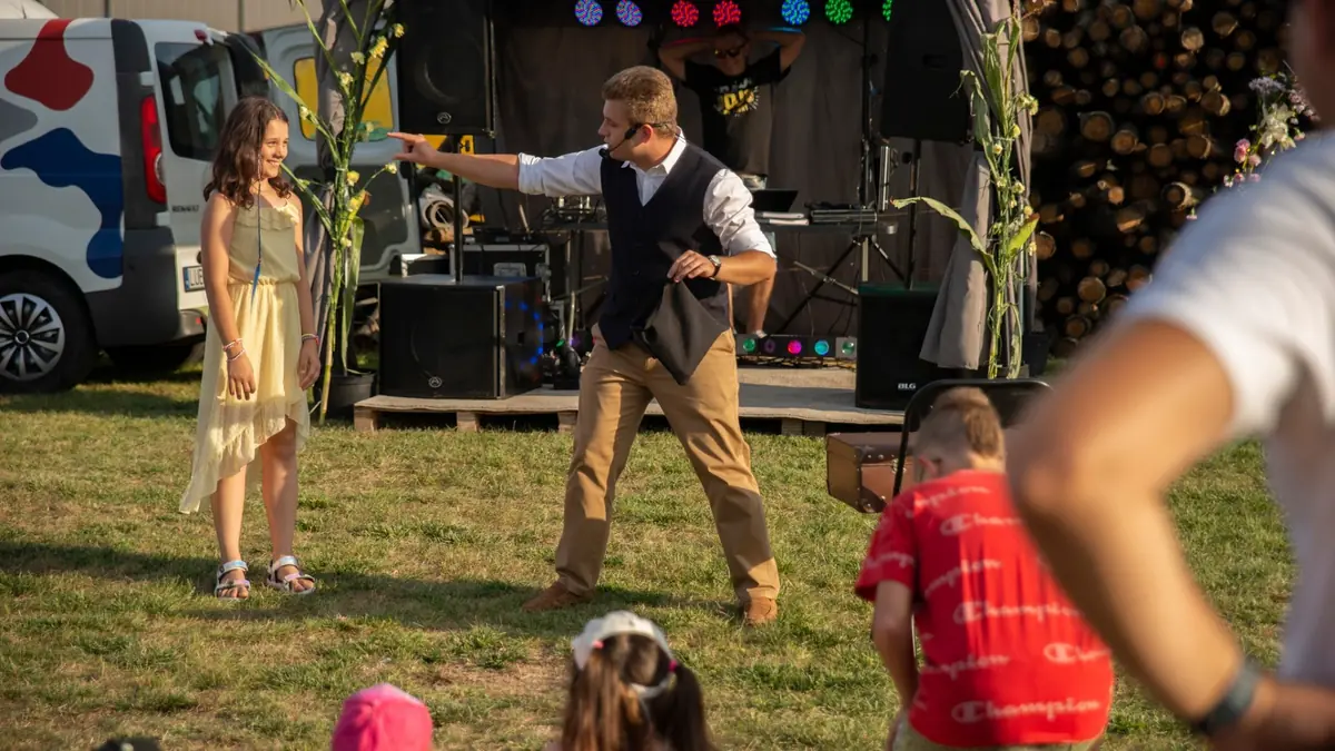 Bartosz Rybczyński z uczestniczką rodzinnego pokazu iluzji w plenerze